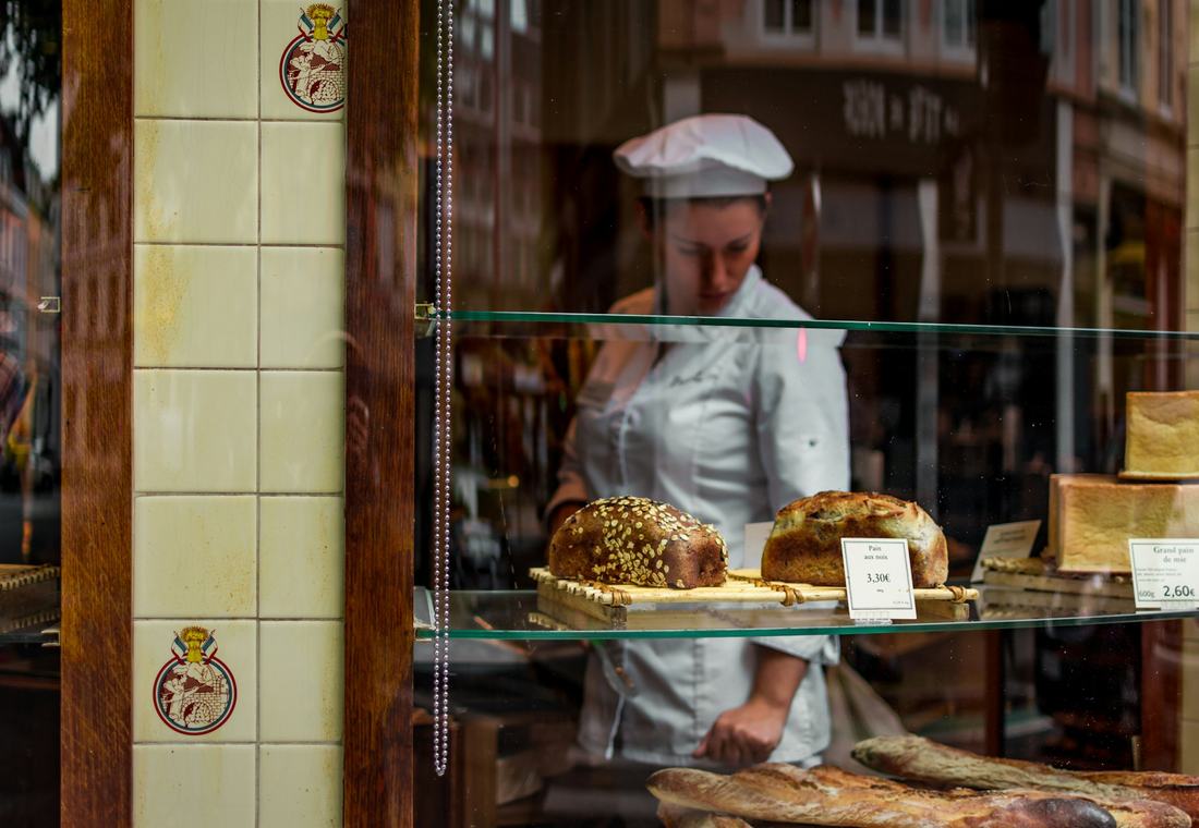 Bakker achter de toonbank van haar winkel